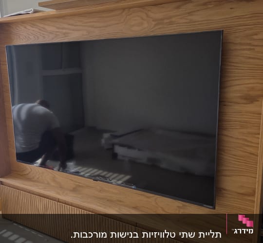 טלוויזיה מותקנת על קיר עץ בחדר מואר